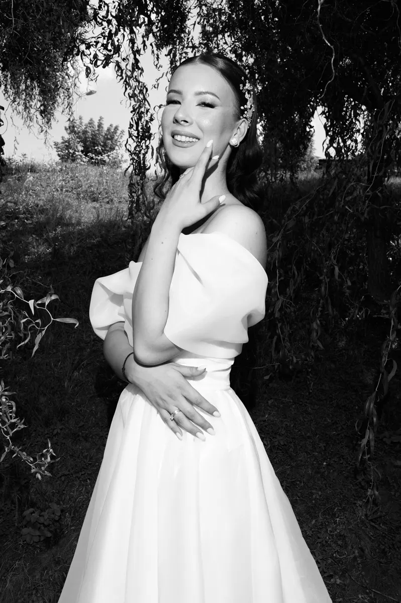 Crno-bela umetnička fotografija mlade ispod drveta na Kalemegdanu, snimljena tokom venčanja u Beogradu.